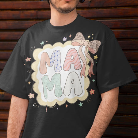 Person wearing a black t-shirt with 'MAMA' design against a wooden background