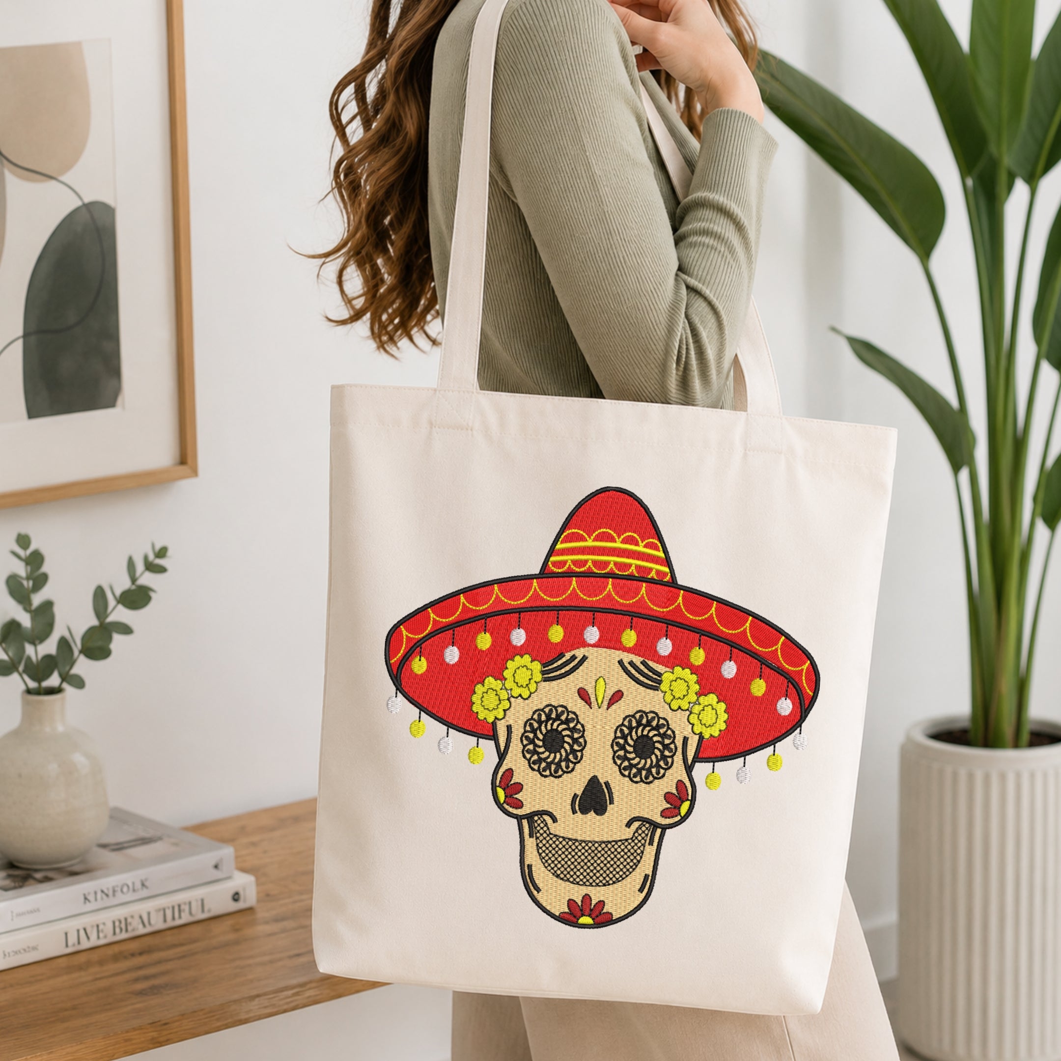 Woman carrying a canvas tote bag decorated with a sugar skull embroidery motif.