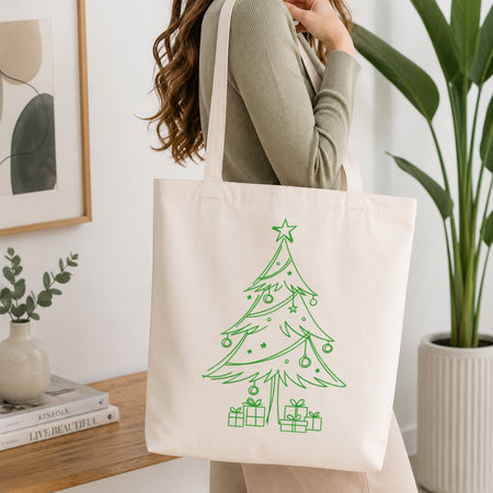 A person holding a cream-colored canvas tote bag featuring the embroidered "Sip, Relax, Repeat" coffee design.