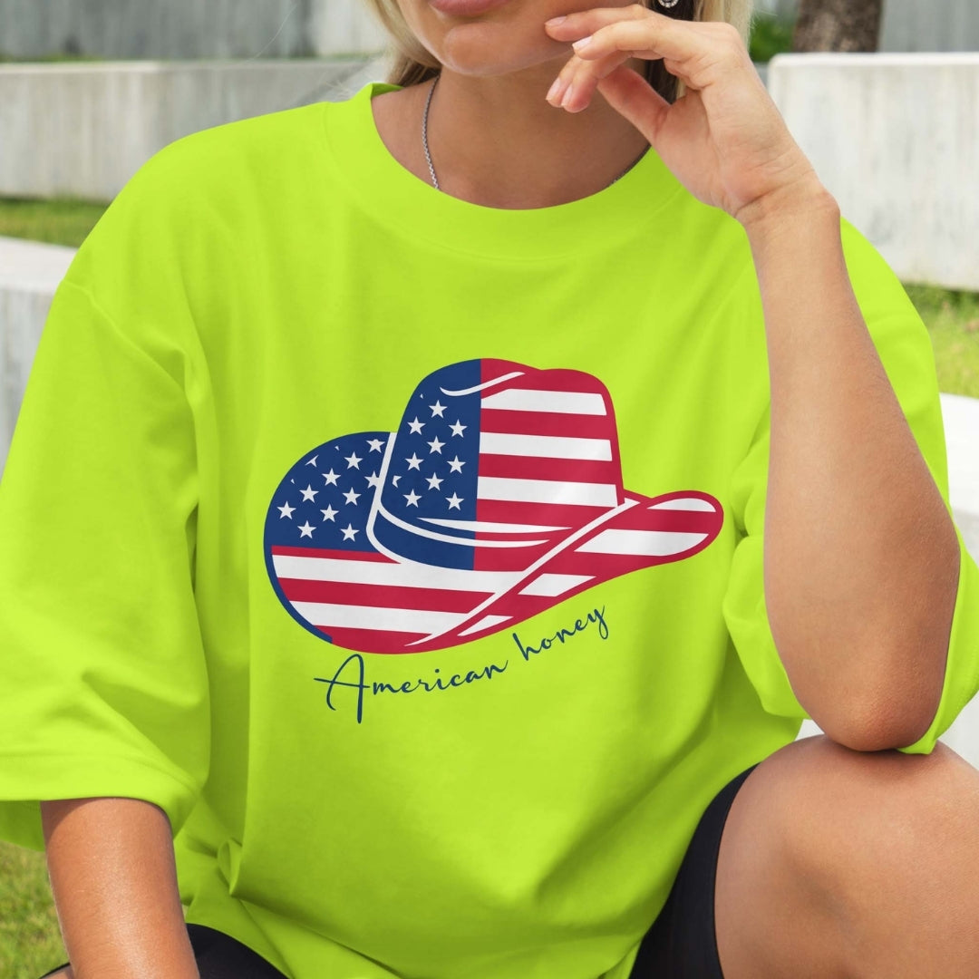 Person wearing a bright green t-shirt with an American flag design and 'American honey' text.