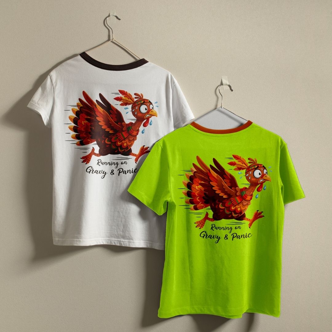 Two ringer t-shirts with a funny cartoon chicken graphic hanging on hangers against a plain beige wall. The left shirt is white with a black collar trim and shows the back graphic.