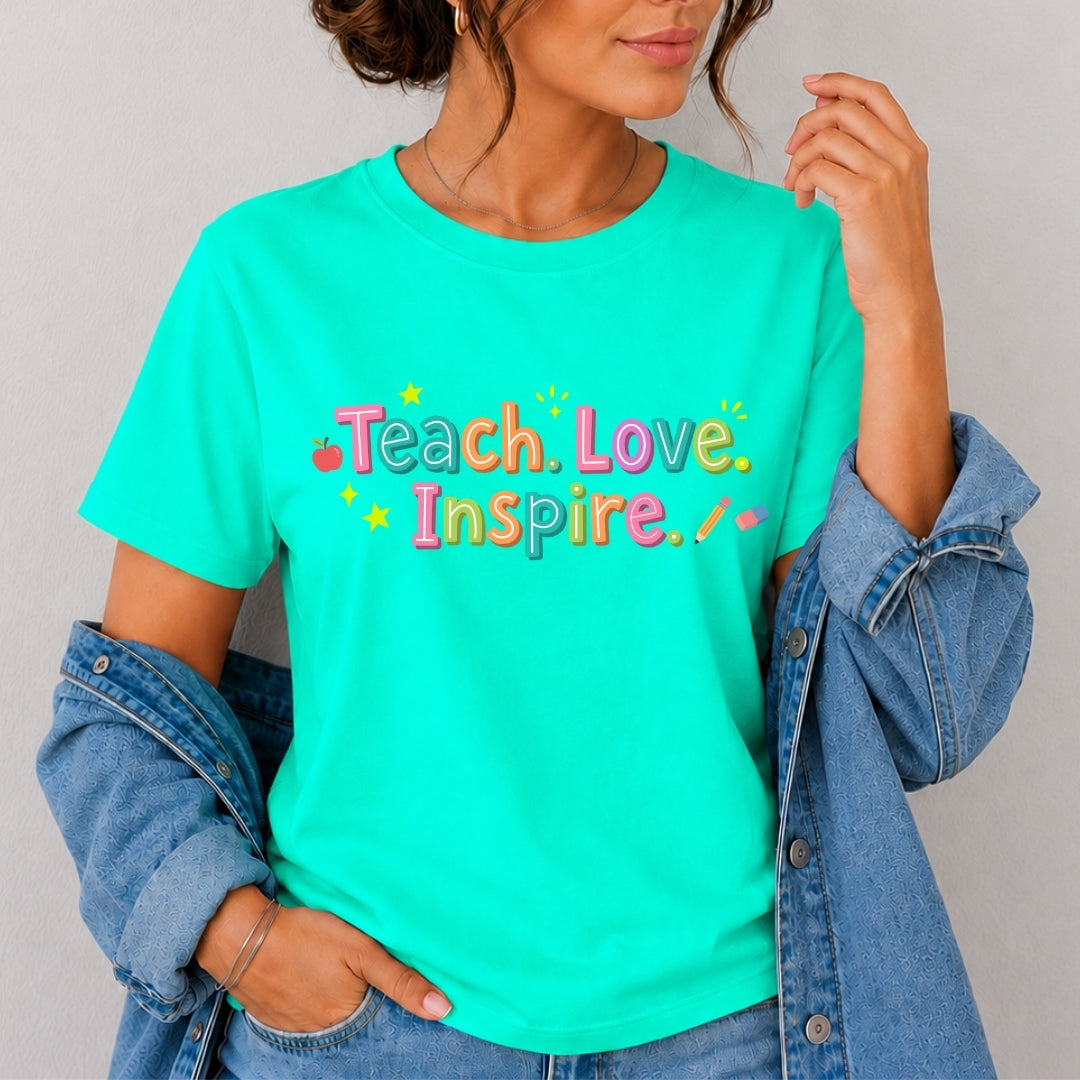 Person wearing a teal t-shirt with 'Teach. Love. Inspire.' text
