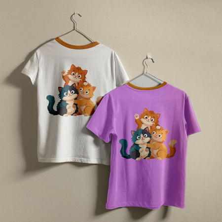 Two t-shirts hanging on a wall—one white and one purple—both featuring the cute cartoon cats graphic print design.