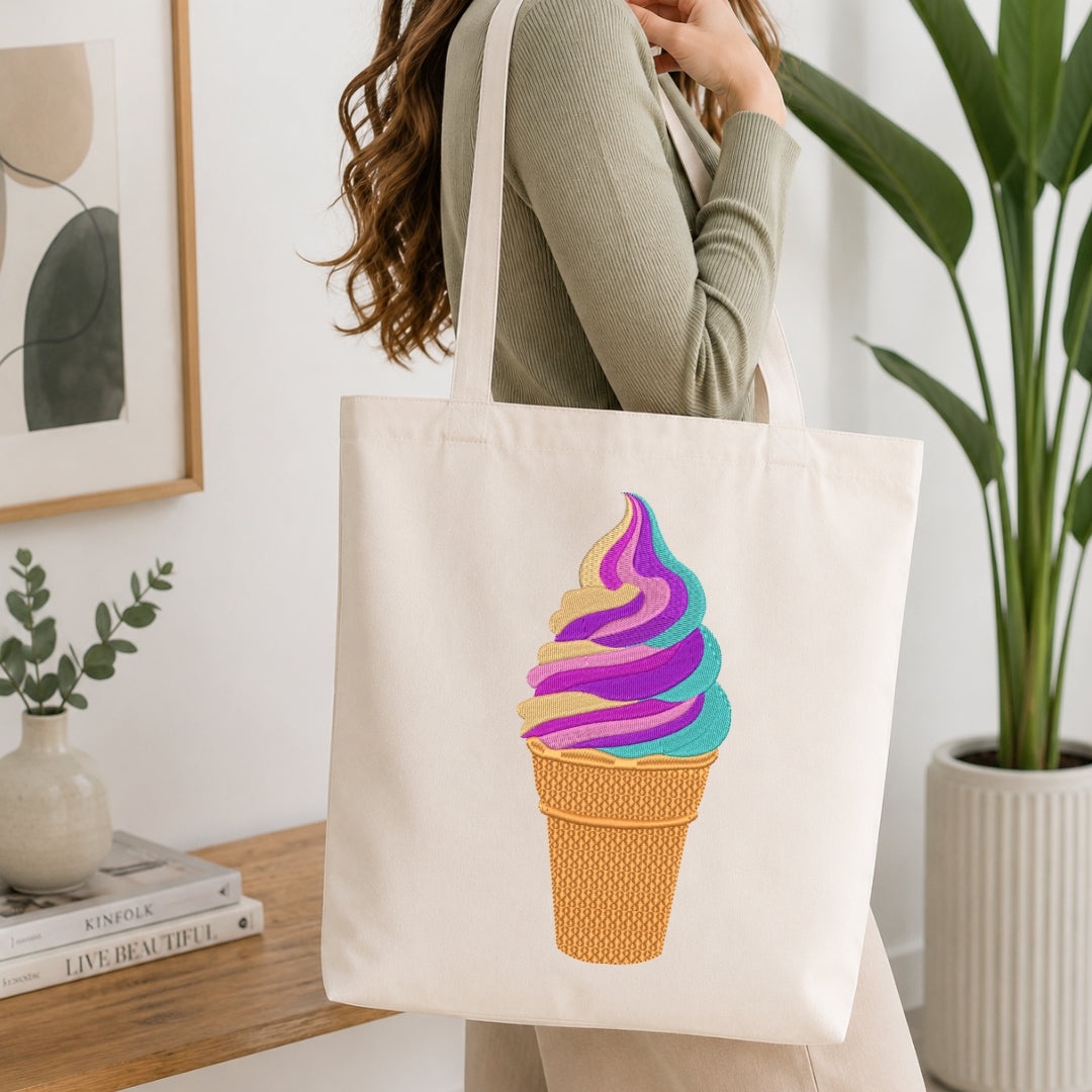 A person wearing a sage green ribbed long-sleeve top carries a cream canvas tote bag with a colorful ice cream cone graphic. The background is a bright, modern room with a wooden table, books, a framed print, and a potted plant.