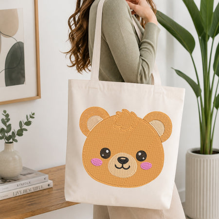 Person holding a tote bag with a bear design in a home setting