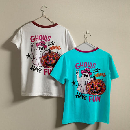 Two t-shirts in white and bright turquoise hanging on hangers, both featuring the back-printed Ghouls Just Wanna Have Fun retro ghost design.