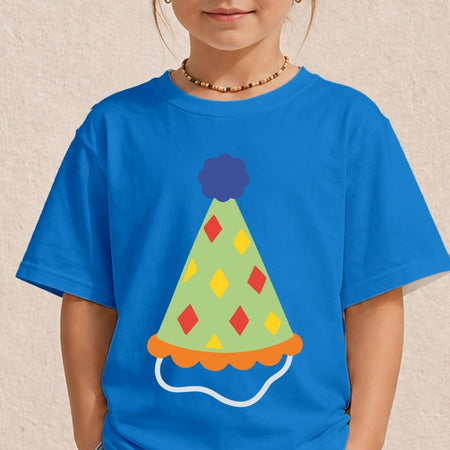 A young girl wearing a bright blue t-shirt printed with a light green party hat featuring red and yellow diamond patterns and a blue pom-pom.