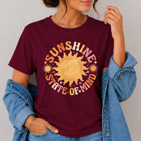 Person wearing a maroon t-shirt with a sun graphic and 'Sunshine State of Mind' text.