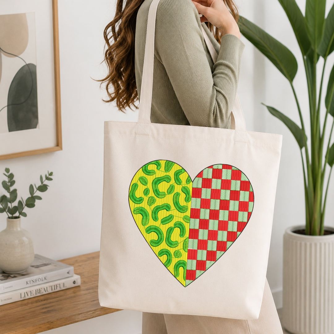 A person wearing a cream canvas tote bag displaying a split leopard print and red checkered heart embroidery design.