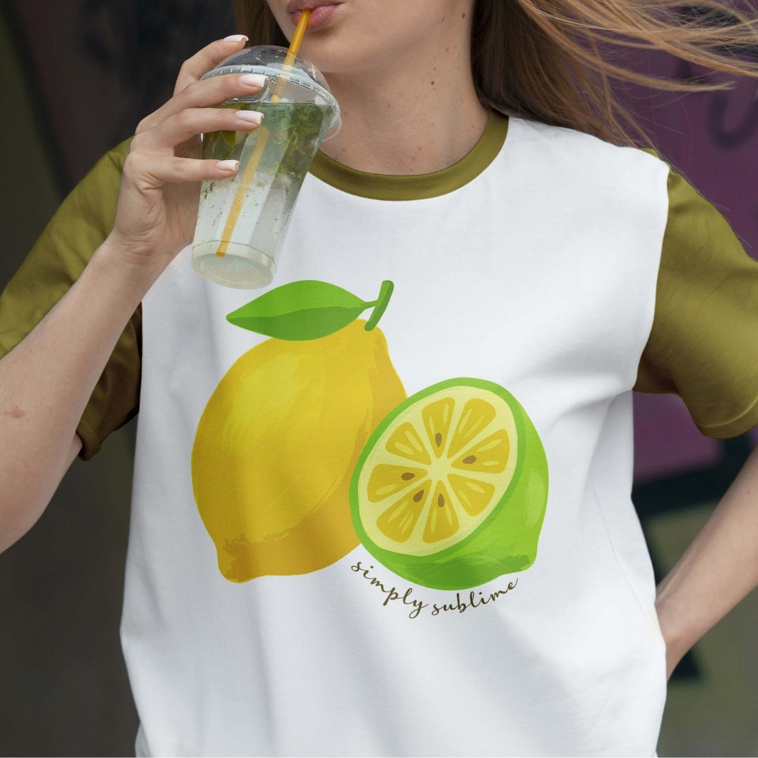 Person wearing a t-shirt with lemon graphics and holding a drink.