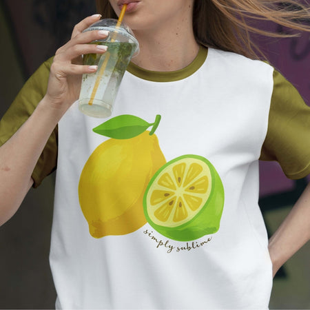 Person wearing a t-shirt with lemon graphics and holding a drink.