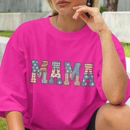 Person wearing a pink t-shirt with 'MAMA' printed in colorful letters.