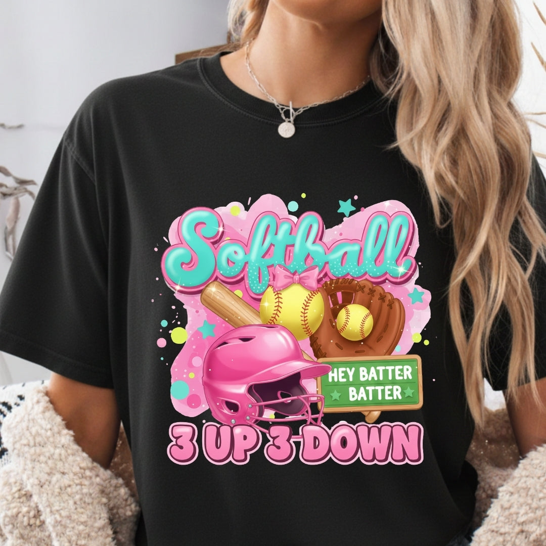 Person wearing a black t-shirt with a colorful softball-themed graphic design.