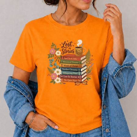 Person wearing an orange t-shirt with a book-themed design on a gray background