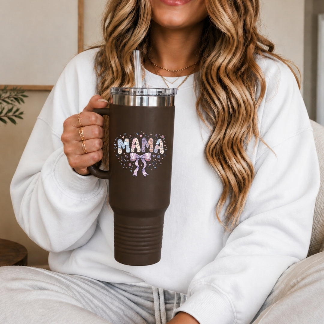 Person holding a brown travel mug with 'MAMA' and a bow design.