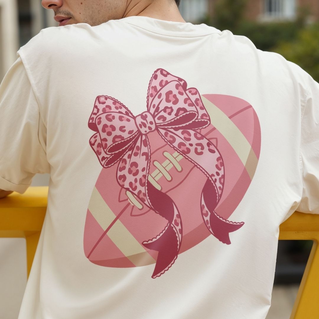 Person wearing a white t-shirt with a pink graphic of a shoe and bow on the back.