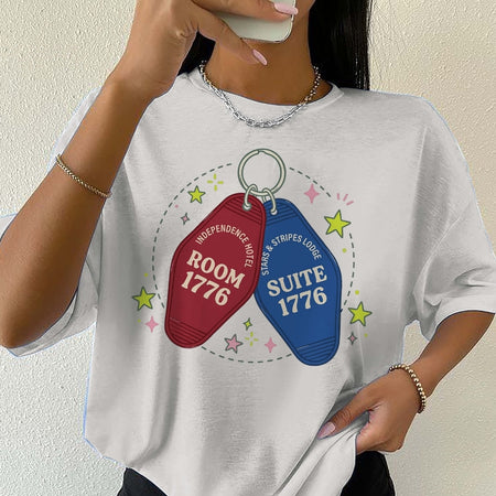 Person wearing a white t-shirt with room and suite keychain graphics and text.