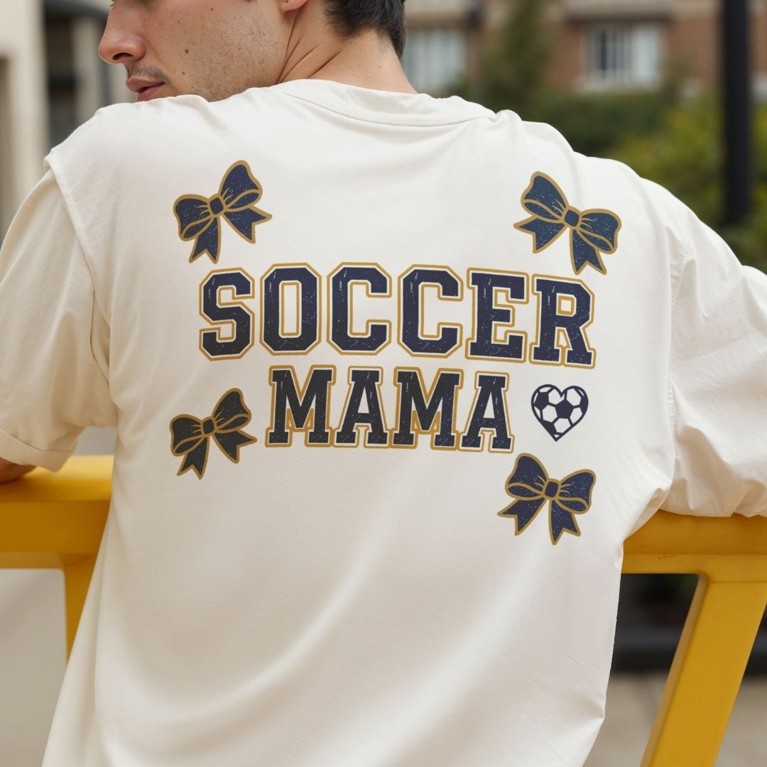 Person wearing a white t-shirt with 'Soccer Mama' text and decorative elements.
