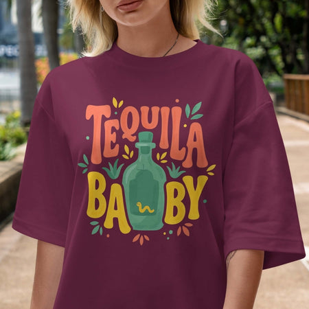 Person wearing a purple t-shirt with 'Tequila Baby' design outdoors.