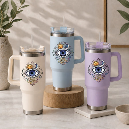 Three insulated travel mugs with eye designs on a neutral background