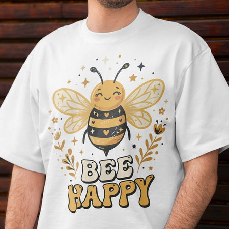 White t-shirt with a bee design and 'Bee Happy' text on a wooden background