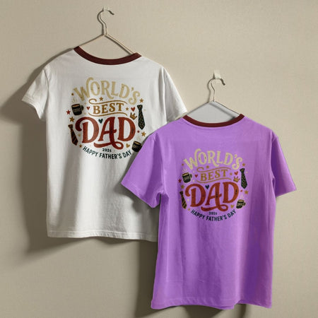 White and purple t-shirts with 'World's Best Dad' text on hangers against a beige background