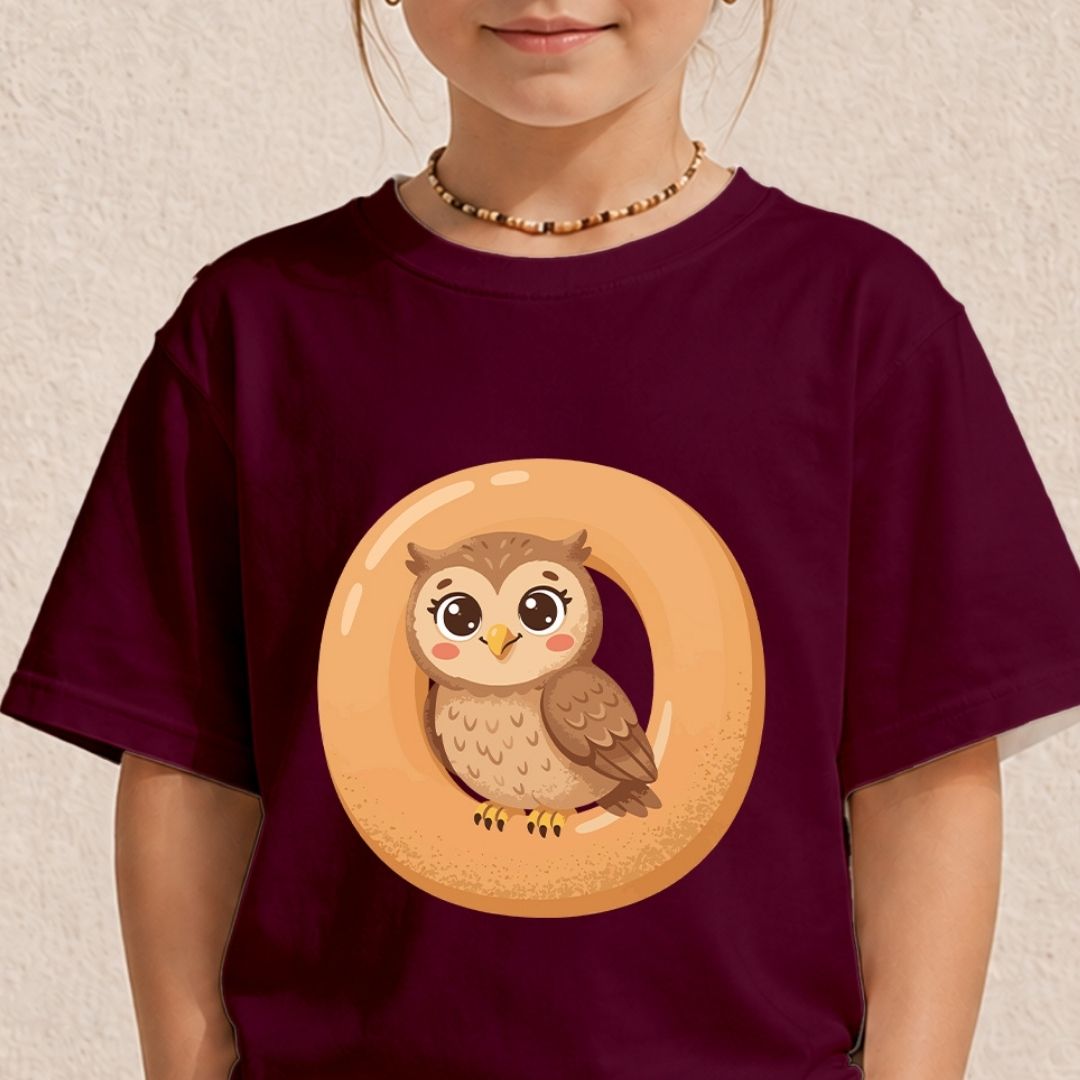 A child wearing a dark maroon t-shirt featuring a warm orange letter O graphic with a cute little brown owl sitting inside it.