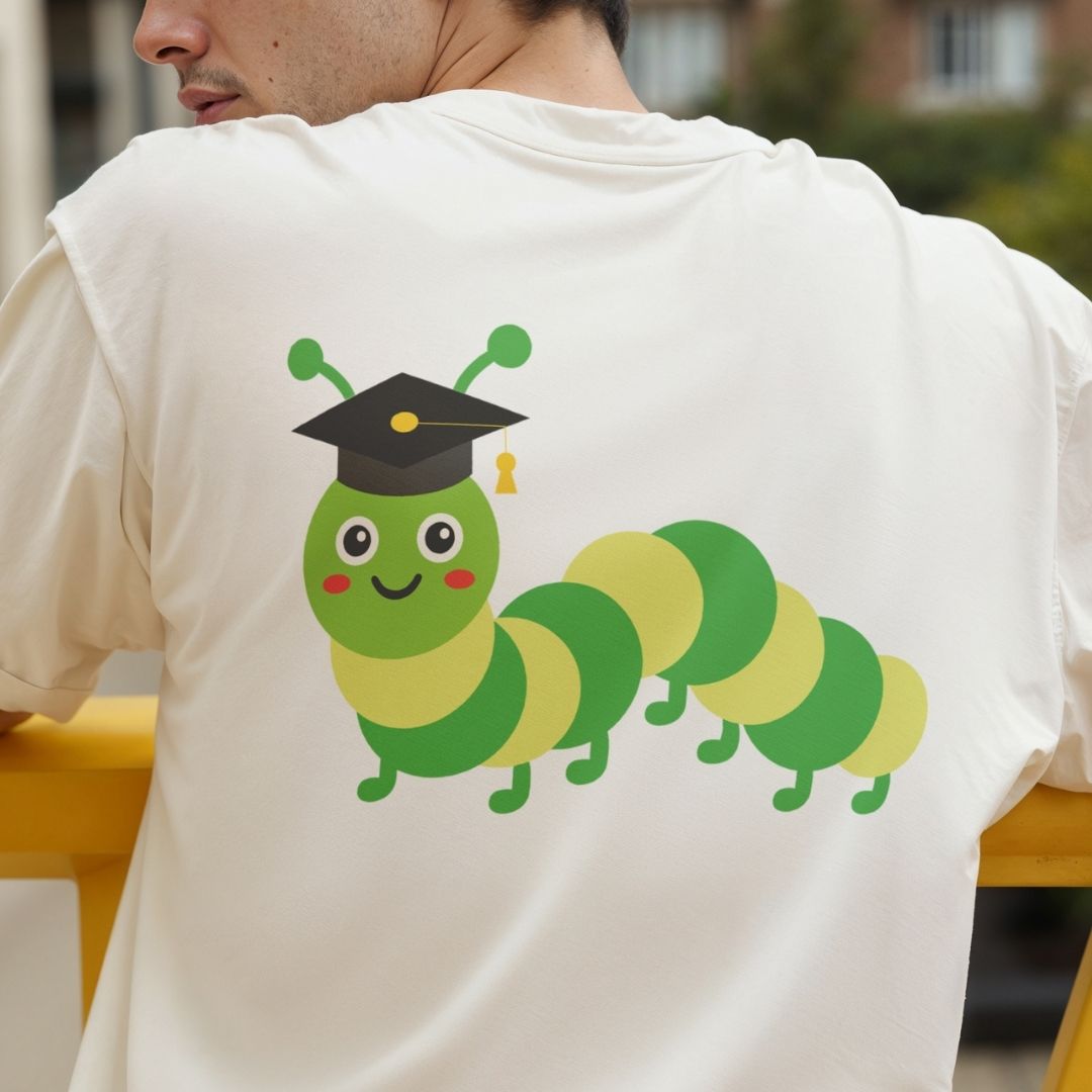 Person wearing a white t-shirt with a cartoon caterpillar in a graduation cap design.