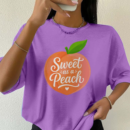 Person wearing a purple t-shirt with 'Sweet as a Peach' design.
