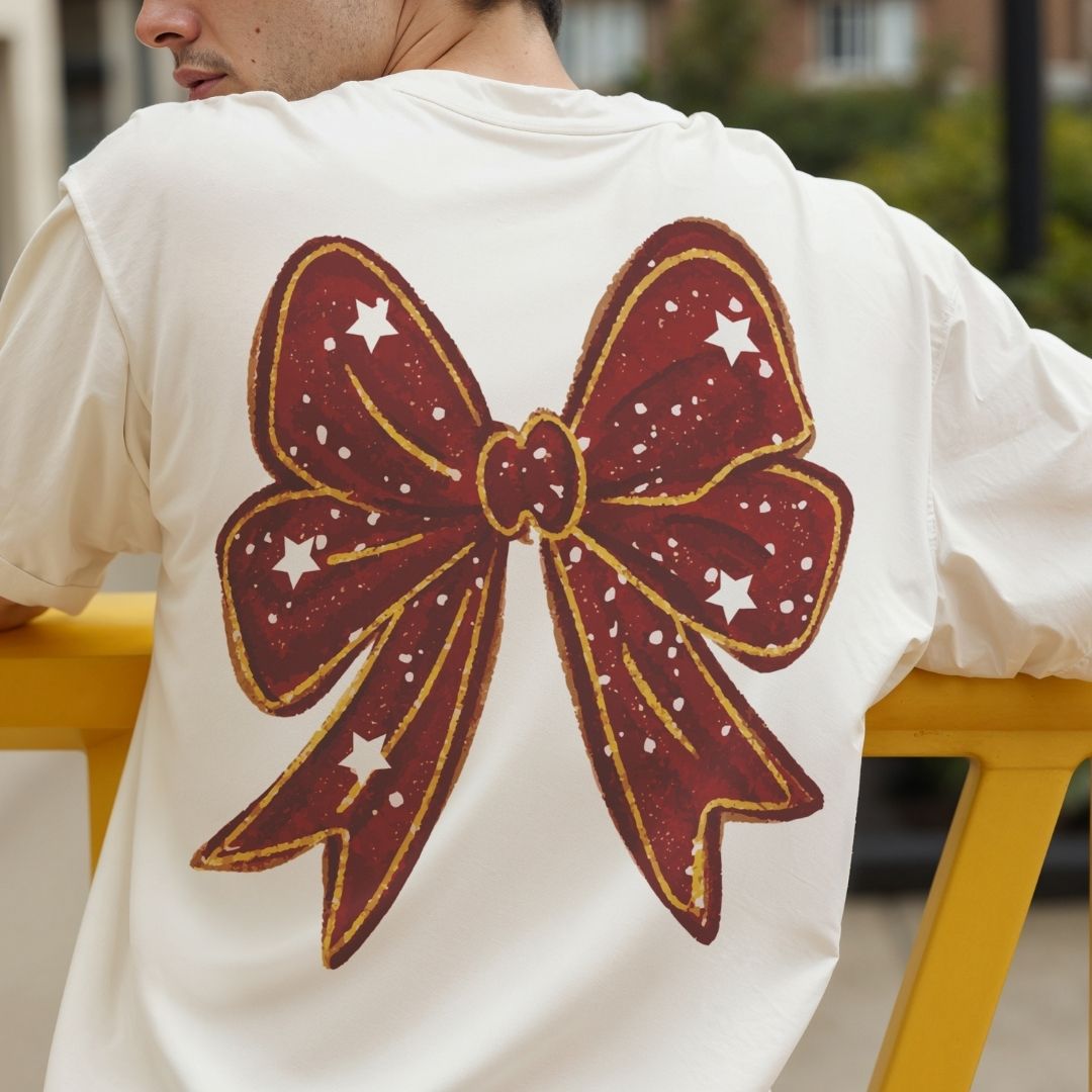 Person wearing a white t-shirt with a large red bow design on the back.