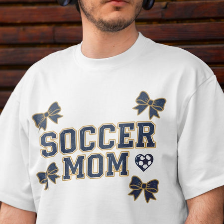 Person wearing a white t-shirt with 'Soccer Mom' text and decorative elements.