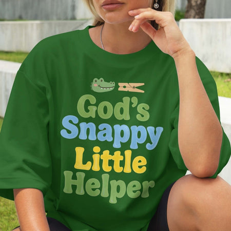 Person wearing a green t-shirt with 'God's Snappy Little Helper' text and graphic.