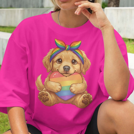 Person wearing a pink t-shirt with a dog holding a rainbow heart design.