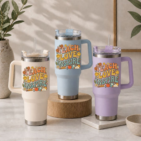 Three insulated tumblers in beige, light blue, and purple, each featuring the vintage-inspired "TEACH LOVE INSPIRE" design.