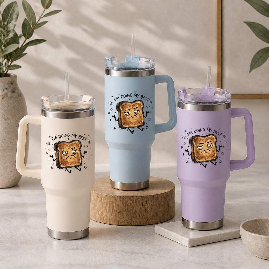 Three insulated tumblers in beige, light blue, and purple, each featuring the humorous burnt toast "I'm doing my best" illustration.