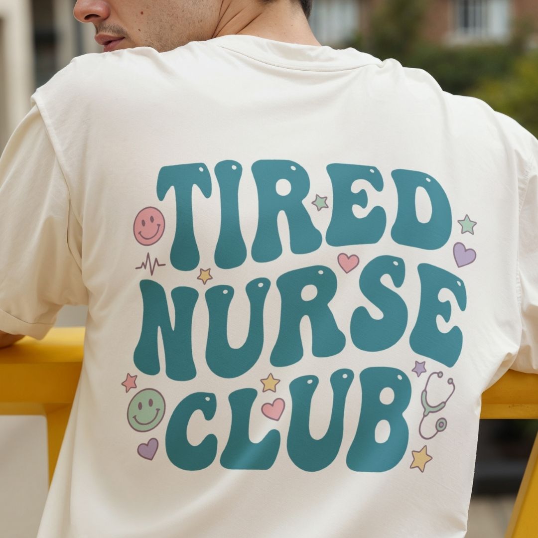 Person wearing a white t-shirt with 'TIRED NURSE CLUB' text and graphics.