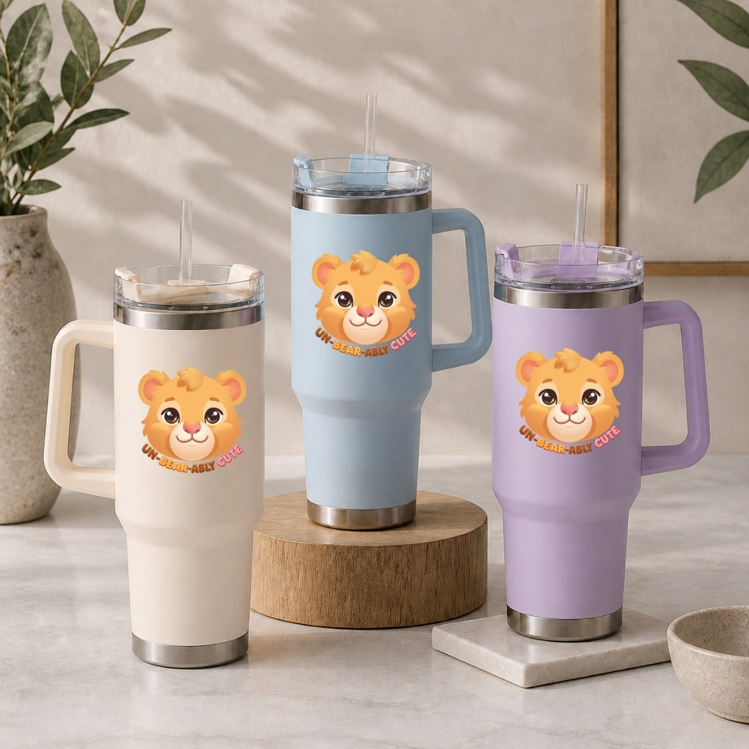 Three large insulated travel tumblers with straws in cream, light blue, and lavender, each featuring the cute bear Un-Bear-Ably Cute graphic.