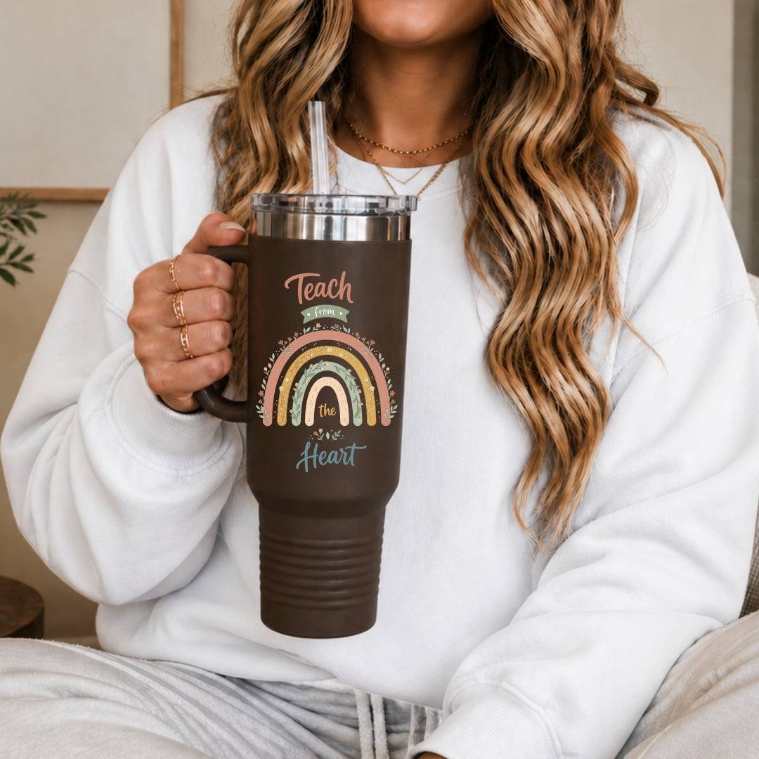 Person holding a brown mug with a rainbow design and text.