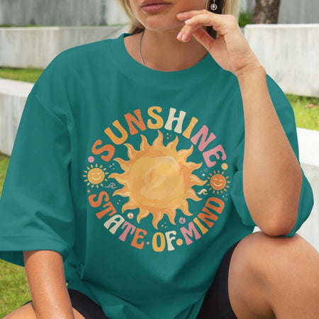 Person wearing a teal t-shirt with a sun graphic and 'Sunshine State of Mind' text.