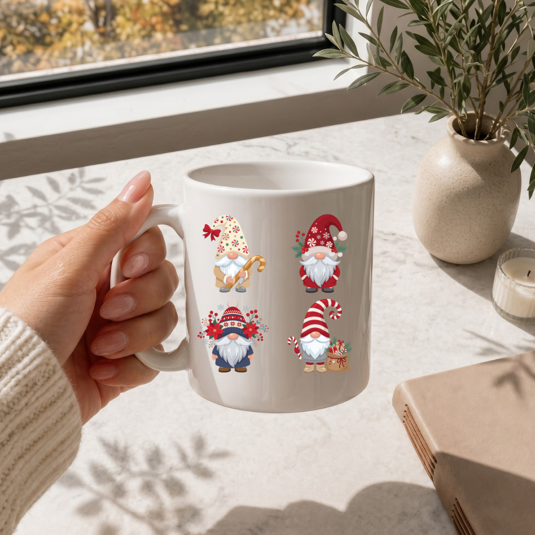 Hand holding a white coffee mug printed with a Christmas gnomes holiday graphic on a marble surface.