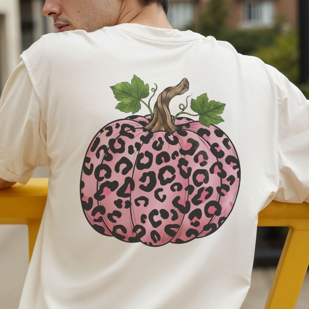 Person wearing a white t-shirt with a pink leopard print pumpkin design on the back.