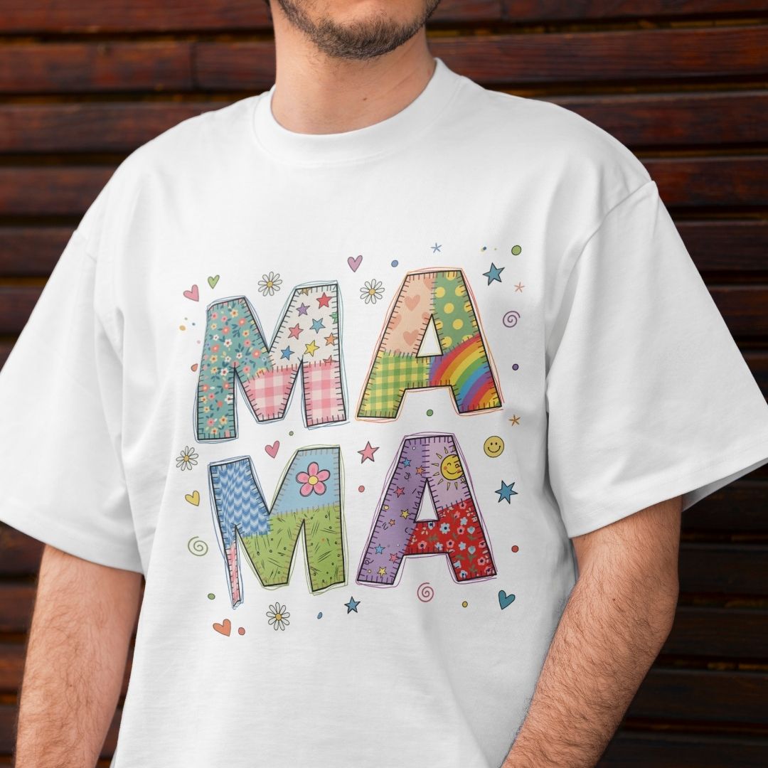 White t-shirt with colorful 'MAMA' design worn by a person against a wooden background