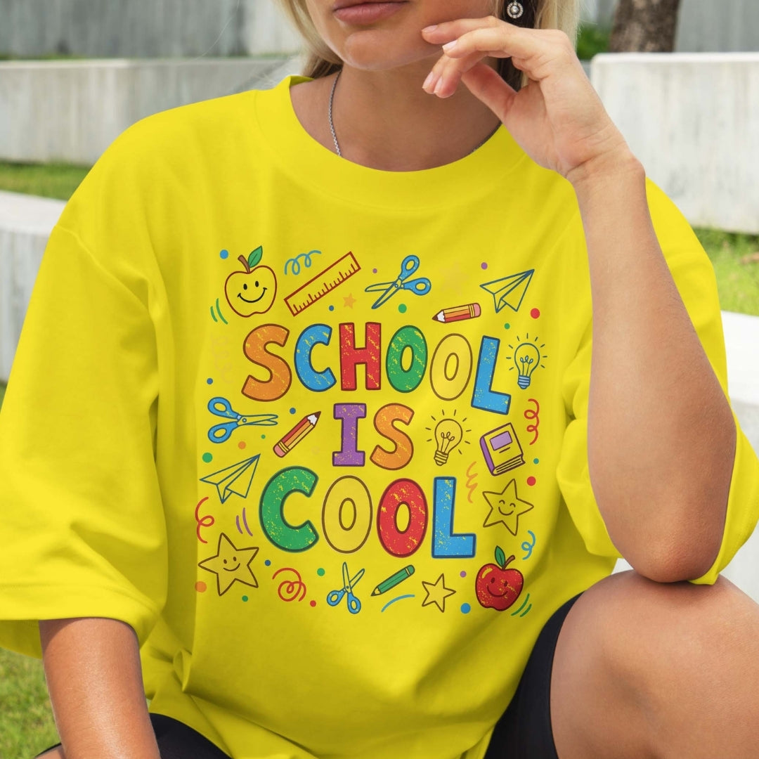 Person wearing a yellow t-shirt with 'School is Cool' text and graphics.