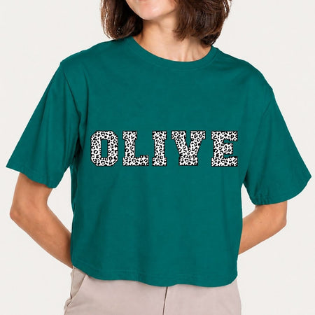 Person wearing a teal t-shirt with 'OLIVE' printed in leopard print.