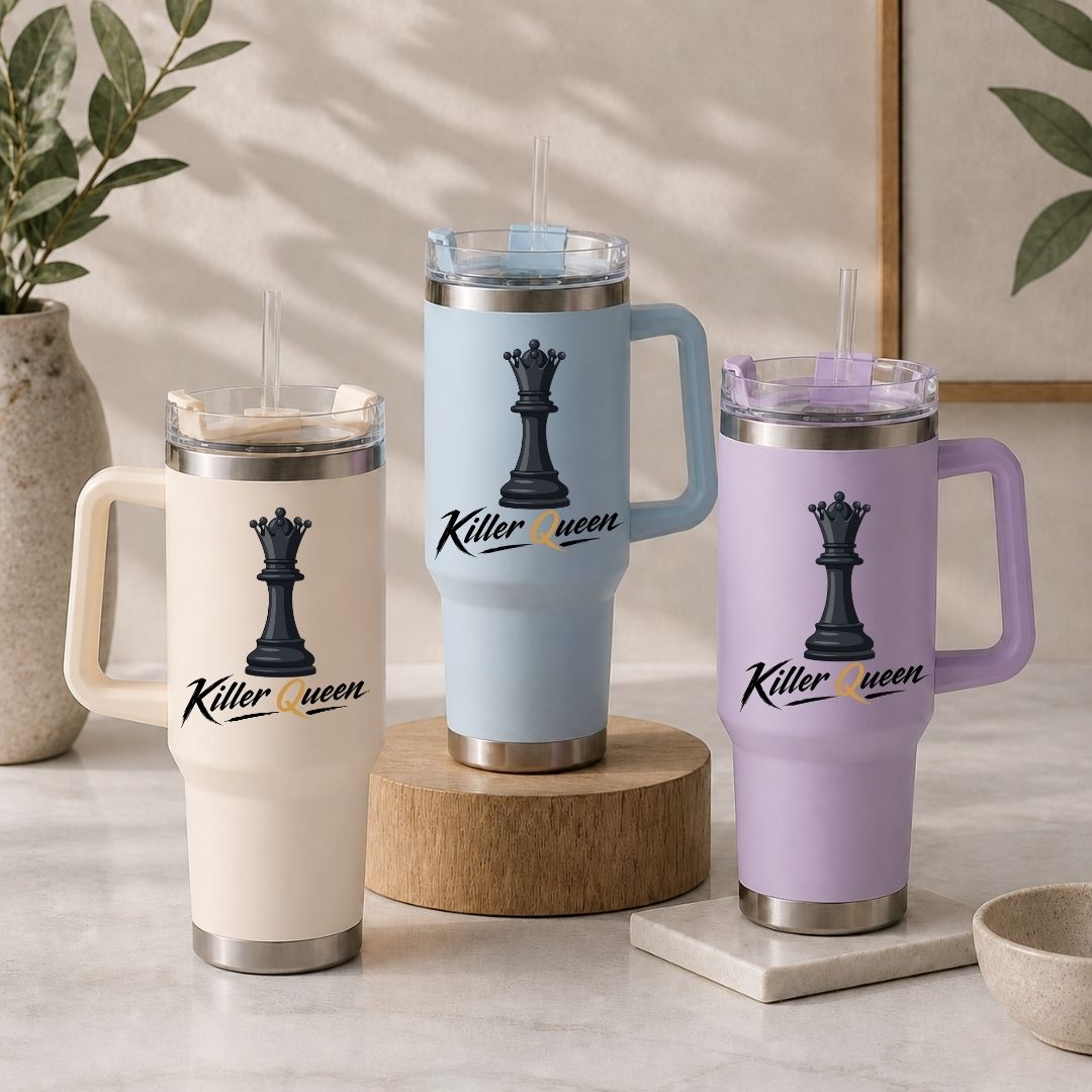 Three handled insulated tumblers with clear lids and straws are displayed on a light stone surface. The tumblers are in cream, light blue, and lavender, each printed with a black chess queen graphic and the words 'Killer queen.