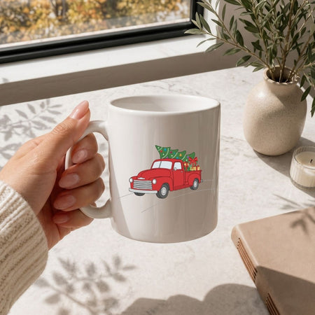 Hand holding a mug with text on a table with a window and plant in the background