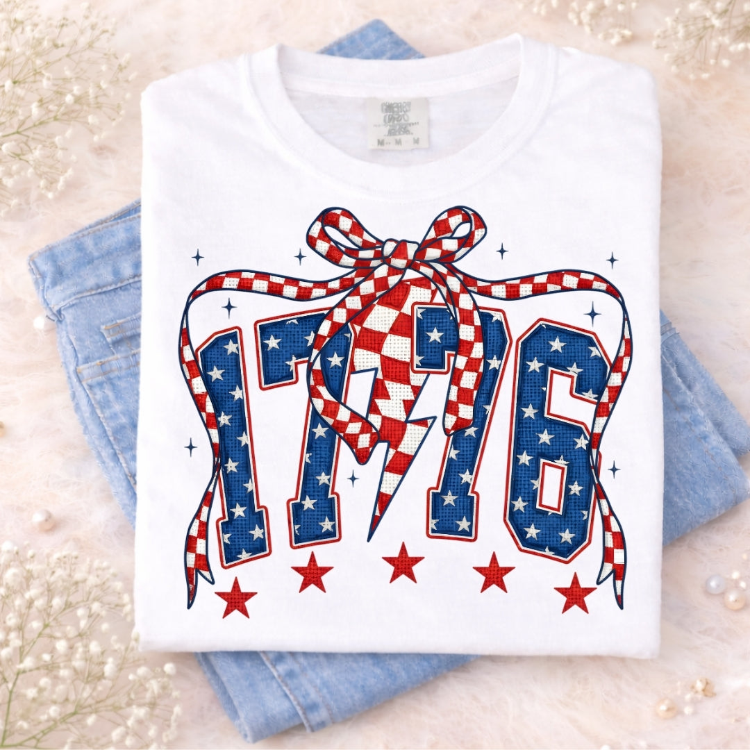 White t-shirt with 'AMC' design featuring stars and a bow on a light background