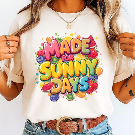 Person wearing a white t-shirt with colorful 'Made for Sunny Days' text and fruit graphics.