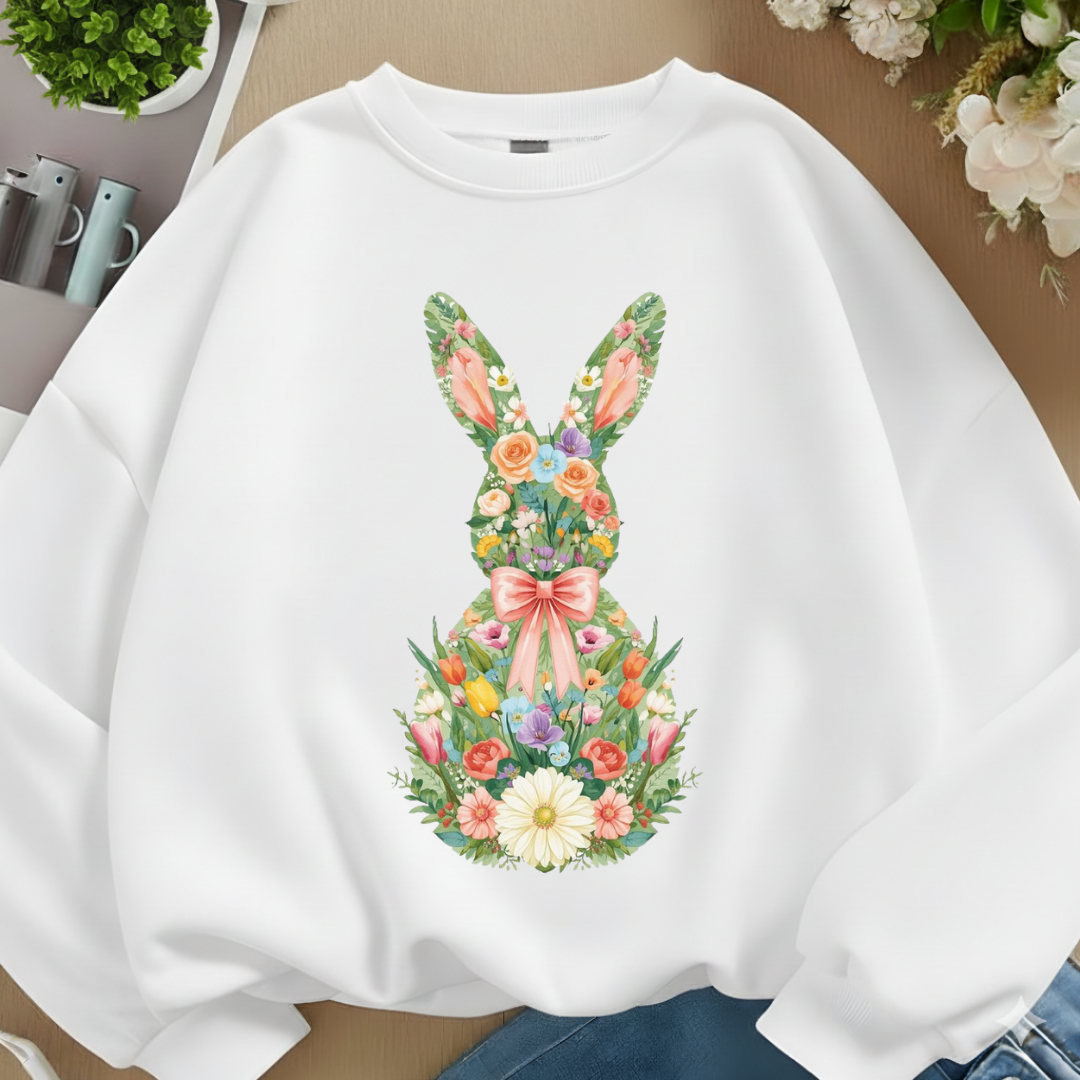 White sweatshirt with floral bunny design on a neutral background