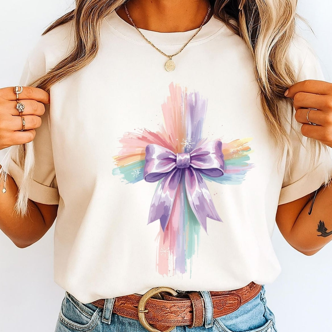 Person wearing a white t-shirt with a colorful bow design on a plain background